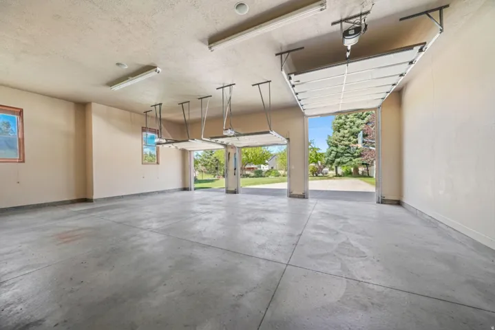 Triple bay garage with overhead doors and concrete flooring