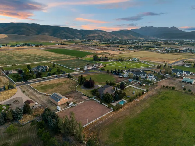 Expansive property with multiple structures, including a main residence and barn, surrounded by agricultural fields and distant mountains