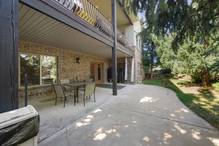 Spacious concrete patio with brick exterior and dual French doors