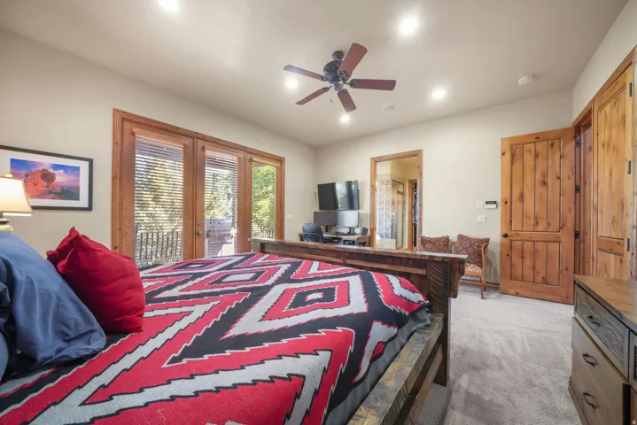 Wood-frame glass patio doors, wood ceiling fan, recessed lighting, and wood paneled doors