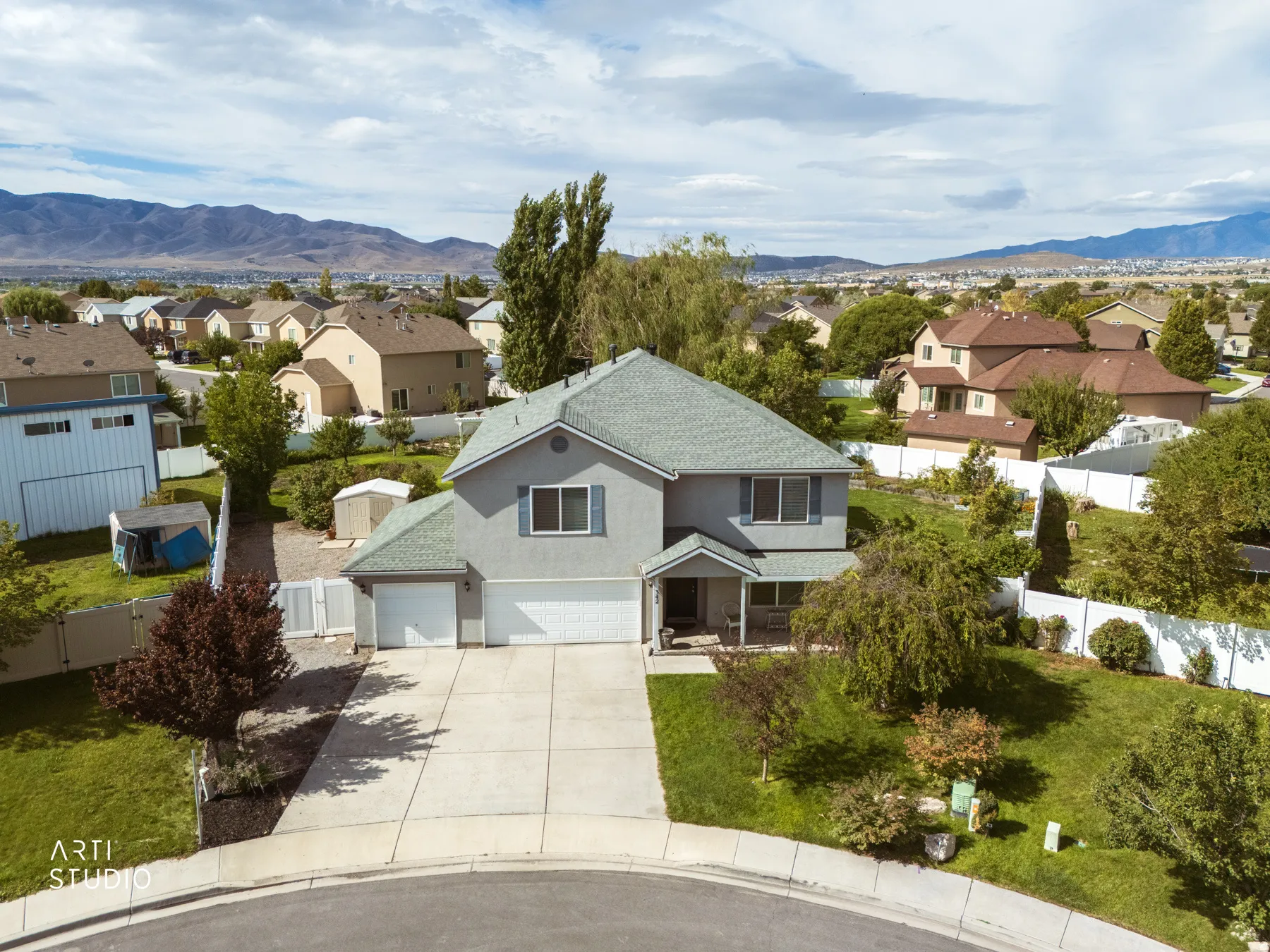 Two-story residence with a light gray exterior and green roof shingles