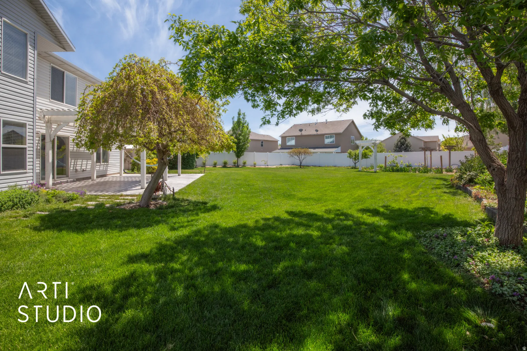 Expansive lawn area, mature trees, and a white picket fence