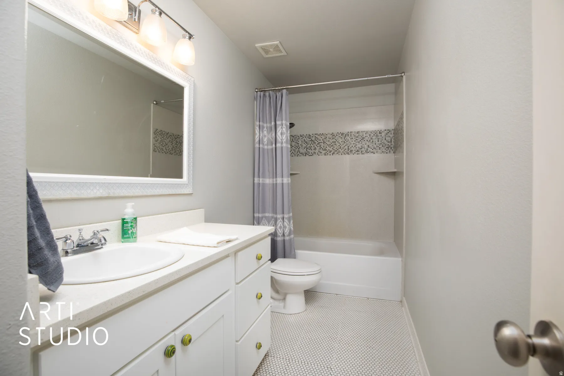 White vanity with ample counter space, integrated sink, and chrome faucet