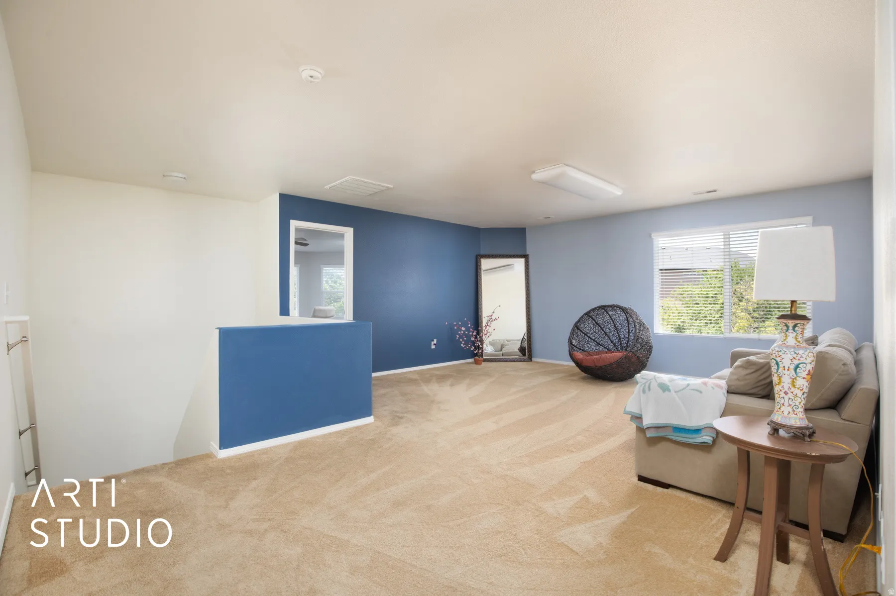 Carpeted flooring throughout, with a partial wall featuring a contrasting accent color
