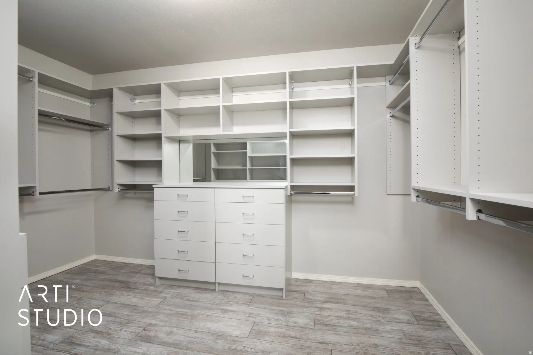 Walk-in closet featuring built-in shelving, hanging rods, an integrated dresser, and a reflective panel