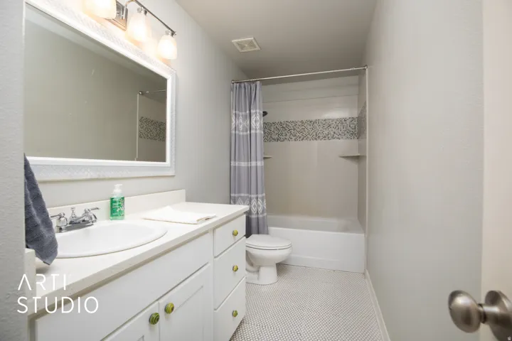 White vanity with ample counter space, integrated sink, and chrome faucet