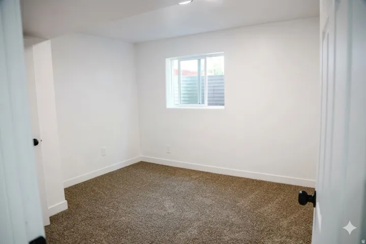Recessed lighting, white walls, carpeted flooring, window with white frame, and white trim