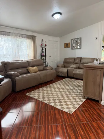 Wood-finish tile flooring, white walls, and a flush mount ceiling light