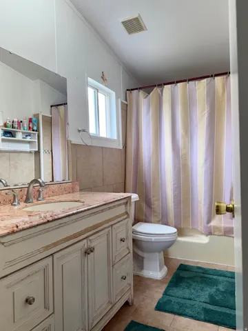 Bathroom featuring a vanity with an integrated sink, polished chrome faucet, and decorative cabinetry