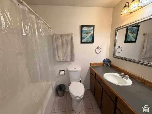 Bathroom featuring a built-in vanity with wood-finish cabinetry, an integrated sink, and an ornamental framed mirror