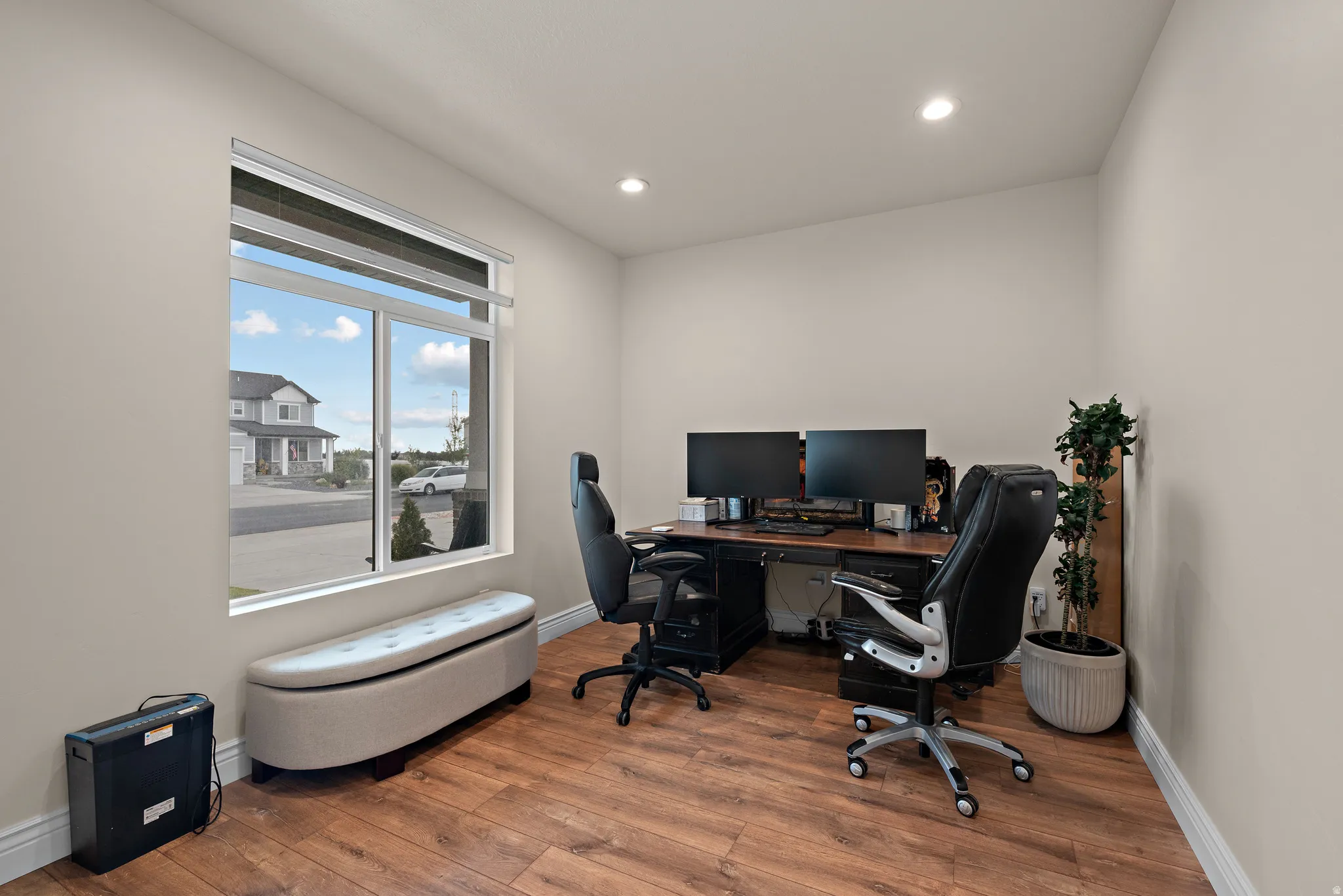 Wood-finish flooring, recessed lighting, and a large window with white trim