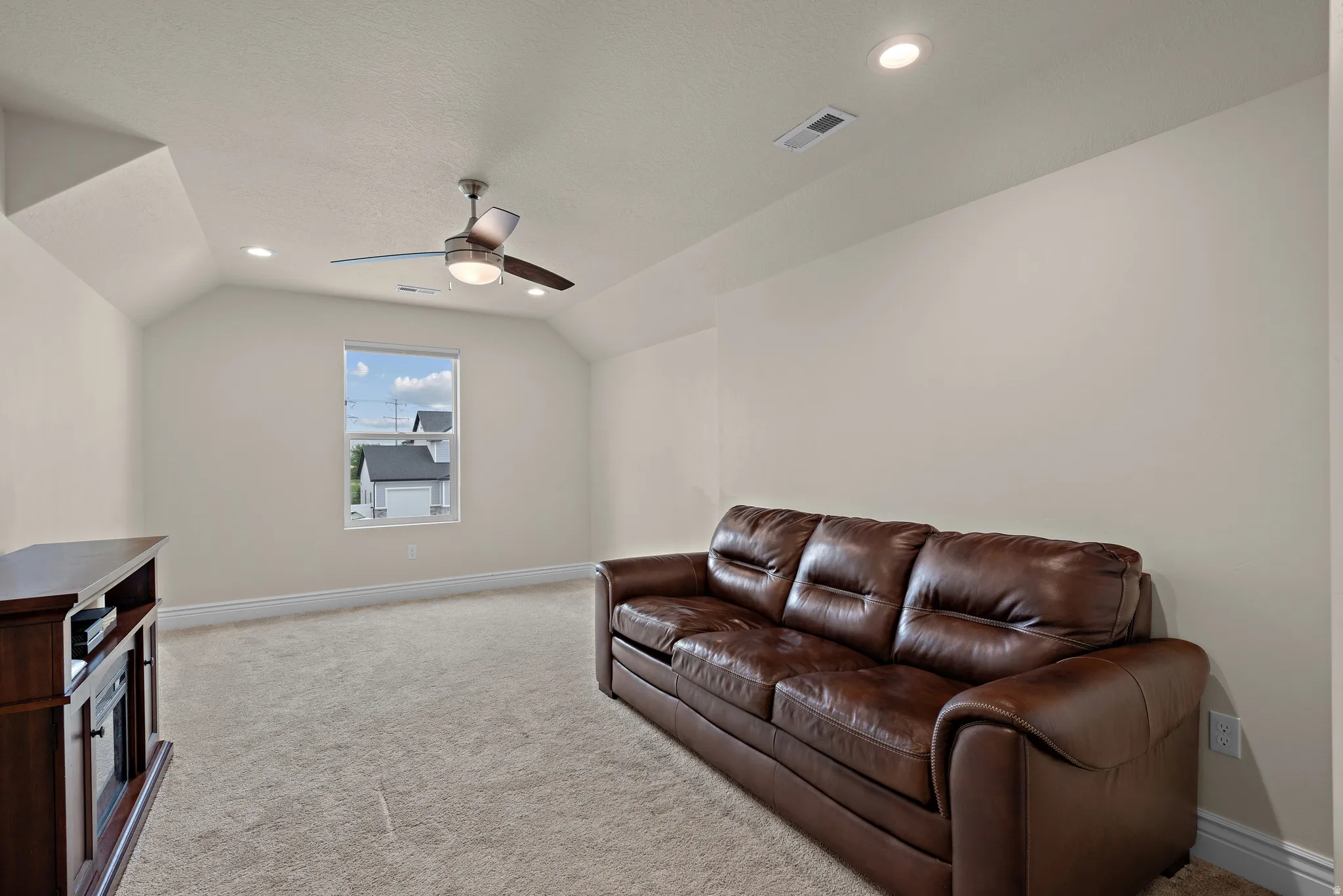 Carpeted room featuring a sloped ceiling, single window, recessed lighting, and a ceiling fan