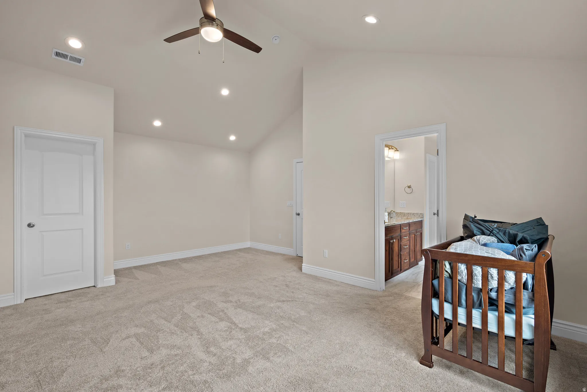 Vaulted ceiling with a ceiling fan, recessed lighting, and neutral carpeting