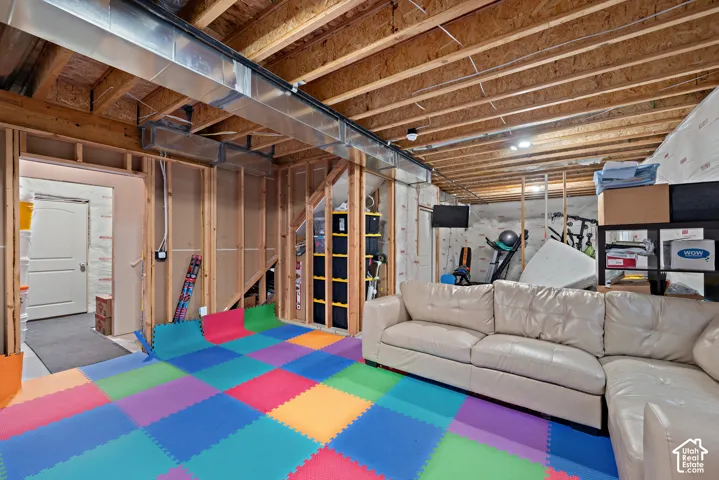 Unfinished basement with exposed wood joists, framed walls, and visible ductwork