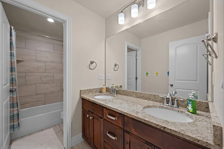 Dual vanity with stone-finish countertop, undermount sinks, and wood-finish cabinetry