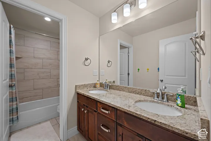 Dual vanity with stone-finish countertop, undermount sinks, and wood-finish cabinetry