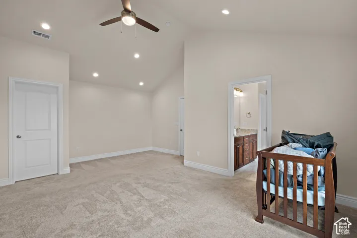 Vaulted ceiling with a ceiling fan, recessed lighting, and neutral carpeting