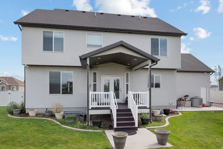 Two-story stucco exterior with a covered patio and deck