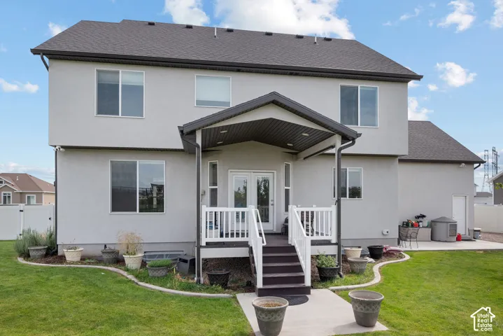 Two-story stucco exterior with a covered patio and deck