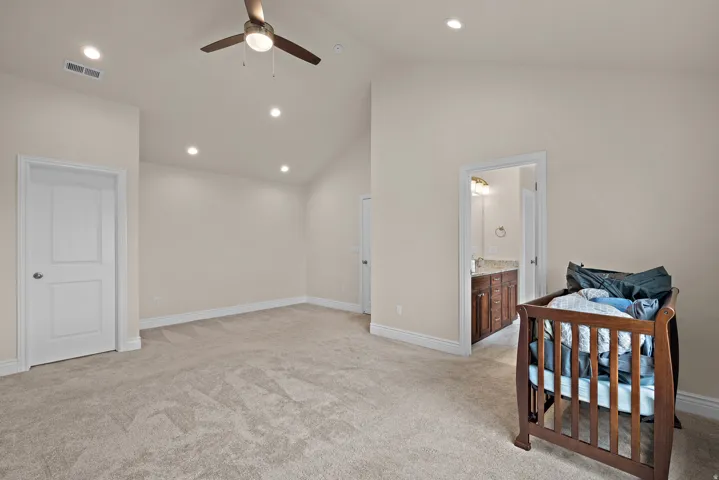 Vaulted ceiling with a ceiling fan, recessed lighting, and neutral carpeting
