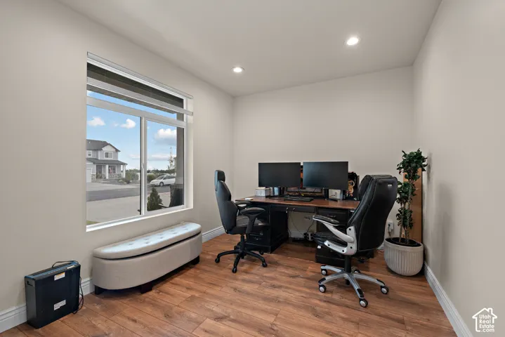 Wood-finish flooring, recessed lighting, and a large window with white trim