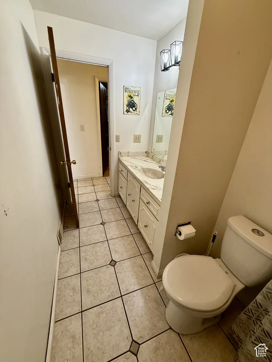 Vanity with an integrated sink, decorative vanity cabinetry, and a light-colored countertop