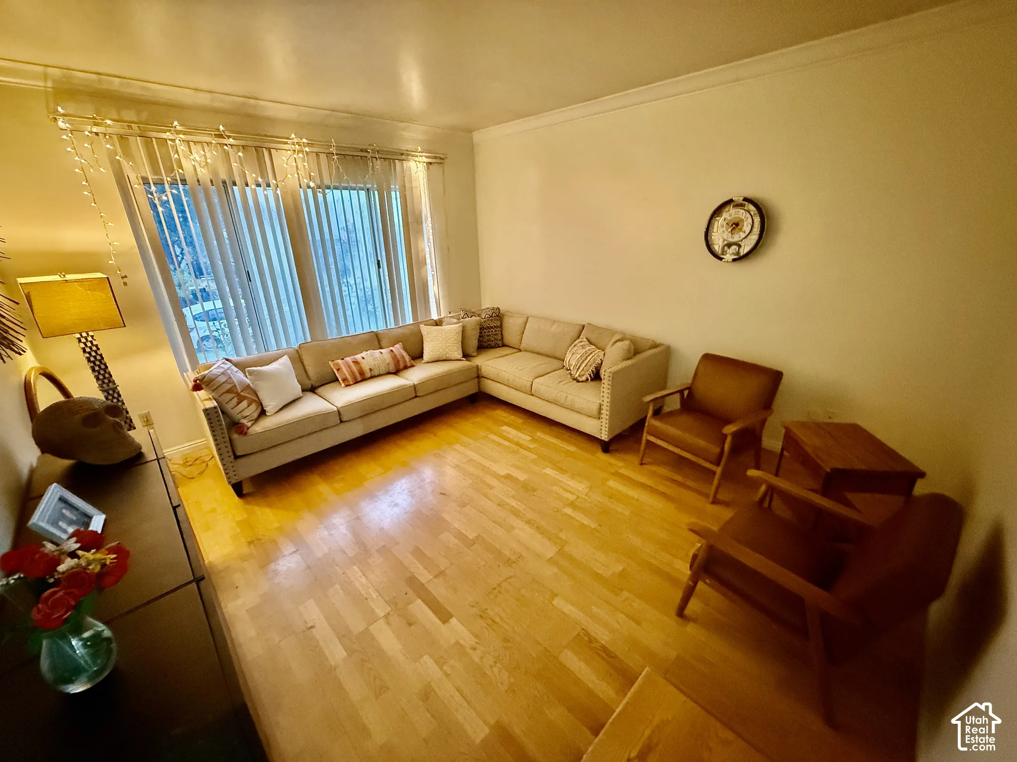Hardwood flooring, crown molding, and large windows with vertical blinds