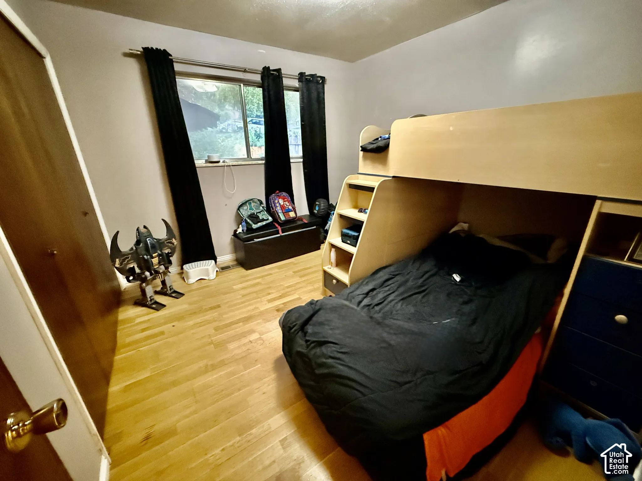 Wood-finish flooring with a horizontal window and dark window treatments