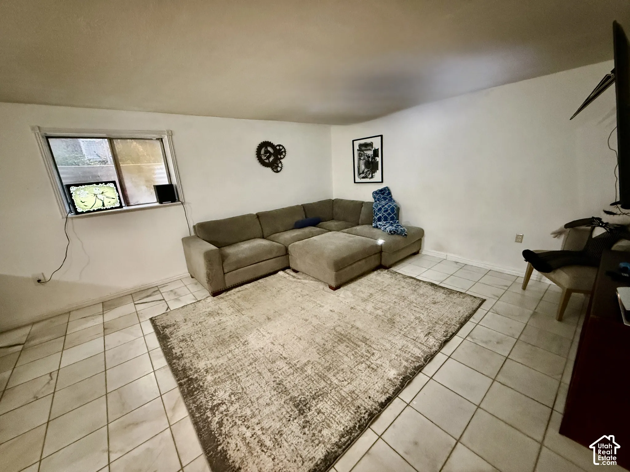 White walls with a window, complemented by light-toned square tile flooring