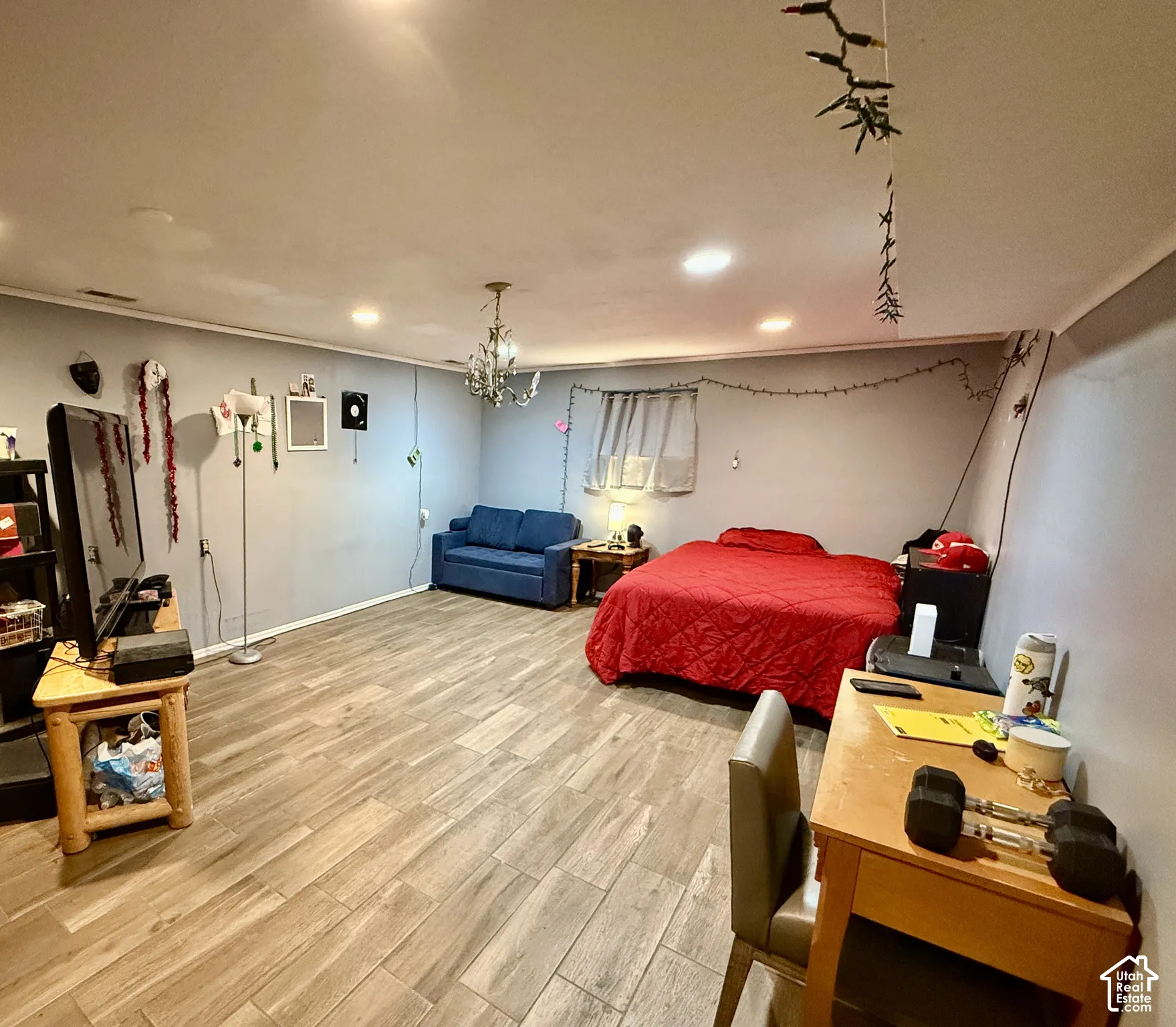 Wood-finish tile flooring throughout, recessed ceiling lighting, and a prominent chandelier fixture