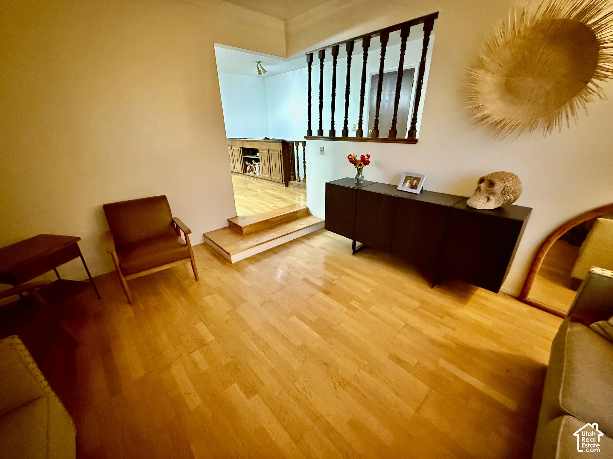 Light wood-finish flooring throughout, featuring a dark wood baluster railing and a built-in dark wood console