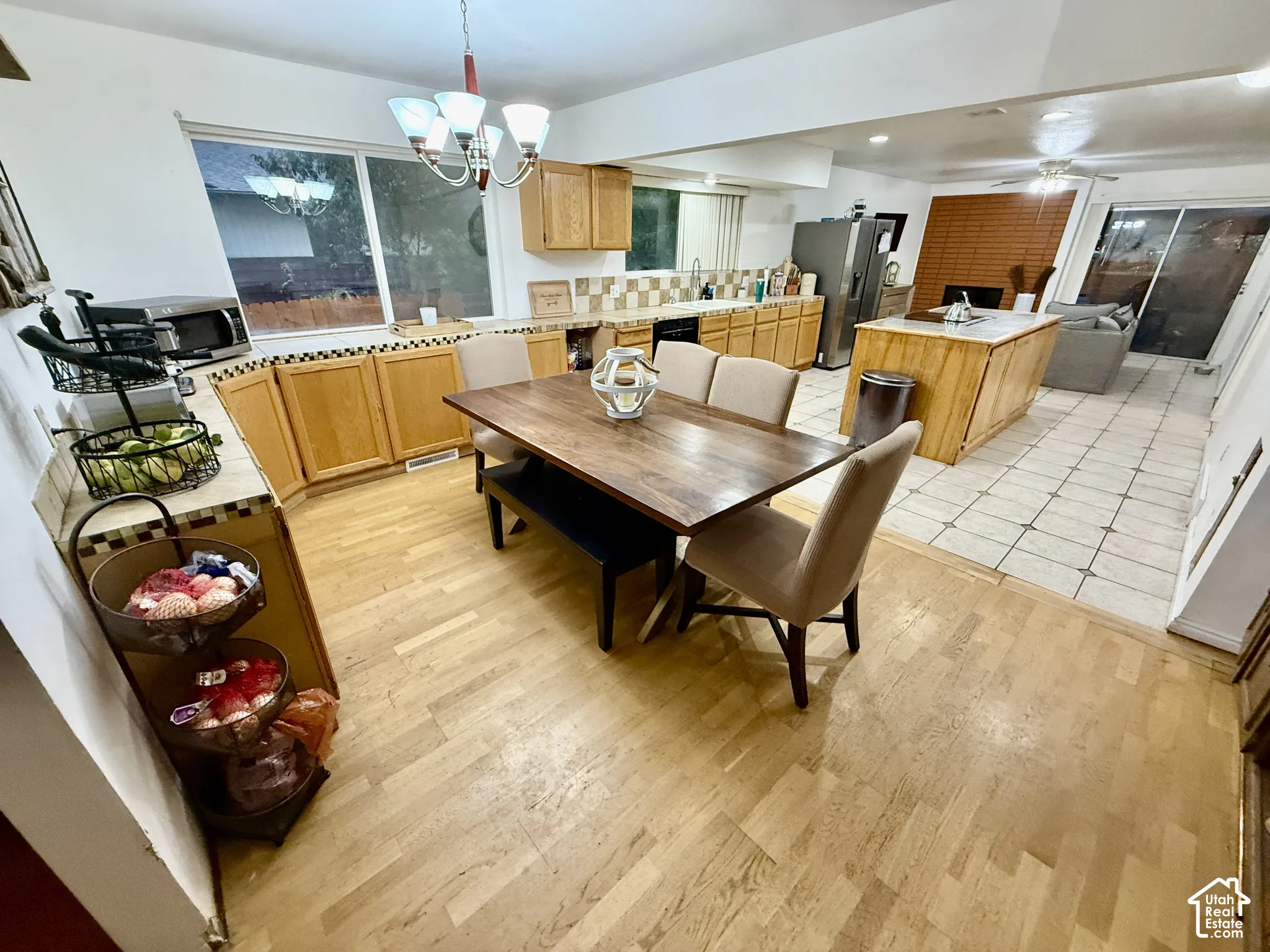 Kitchen featuring light wood-finish cabinetry, a central island with a light-toned countertop, and a built-in stainless steel refrigerator