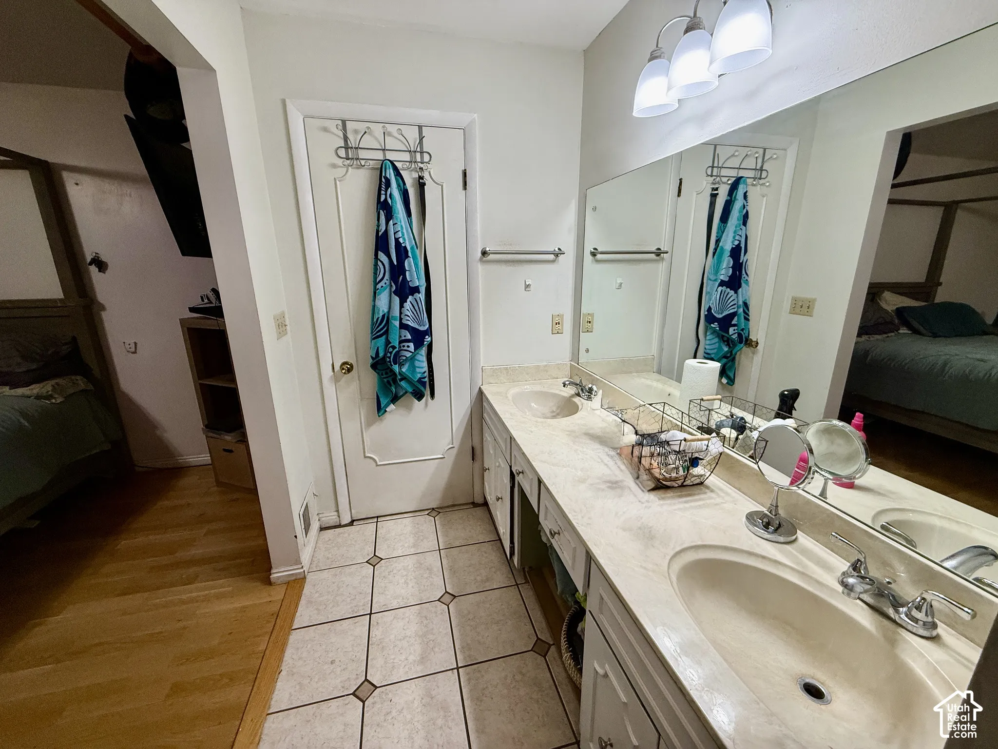 Dual sink vanity with an expansive countertop, integrated rectangular sinks, and a large wall-mounted mirror