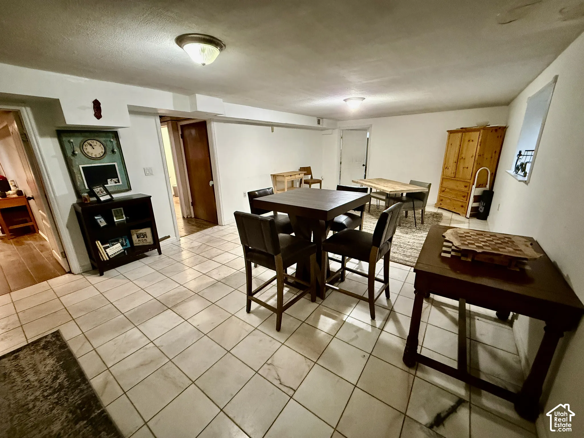 Tiled flooring, white painted walls, and ceiling-mounted light fixtures