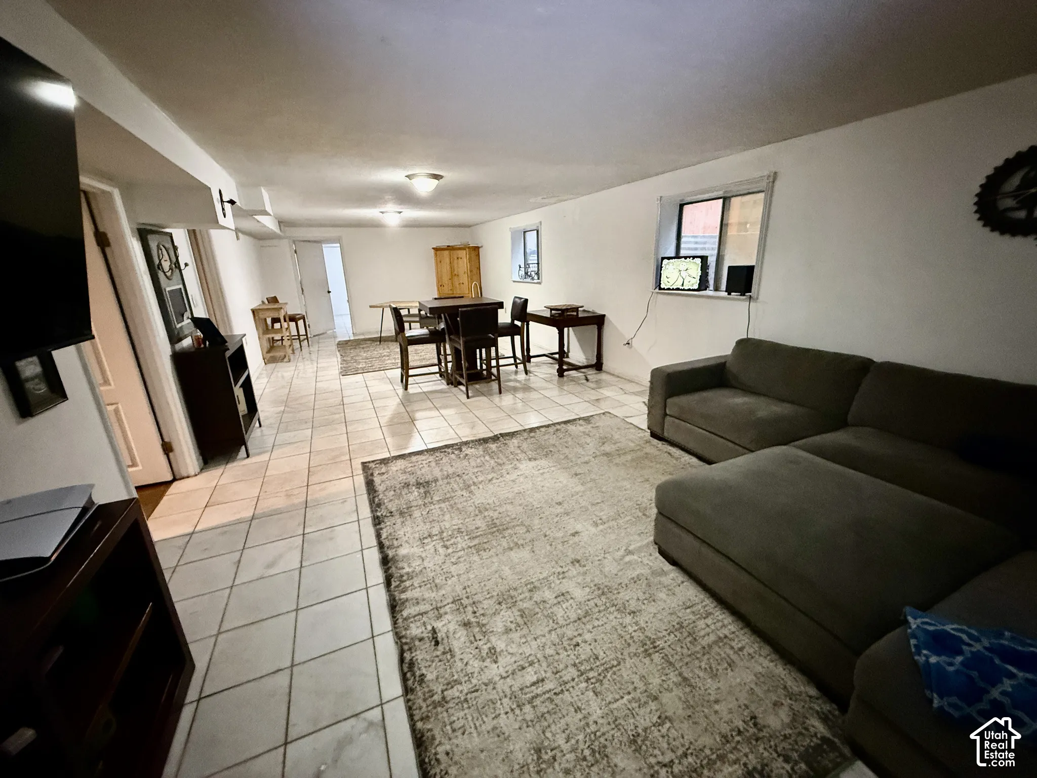 Spacious room featuring tile flooring, white walls, and multiple ceiling-mounted light fixtures