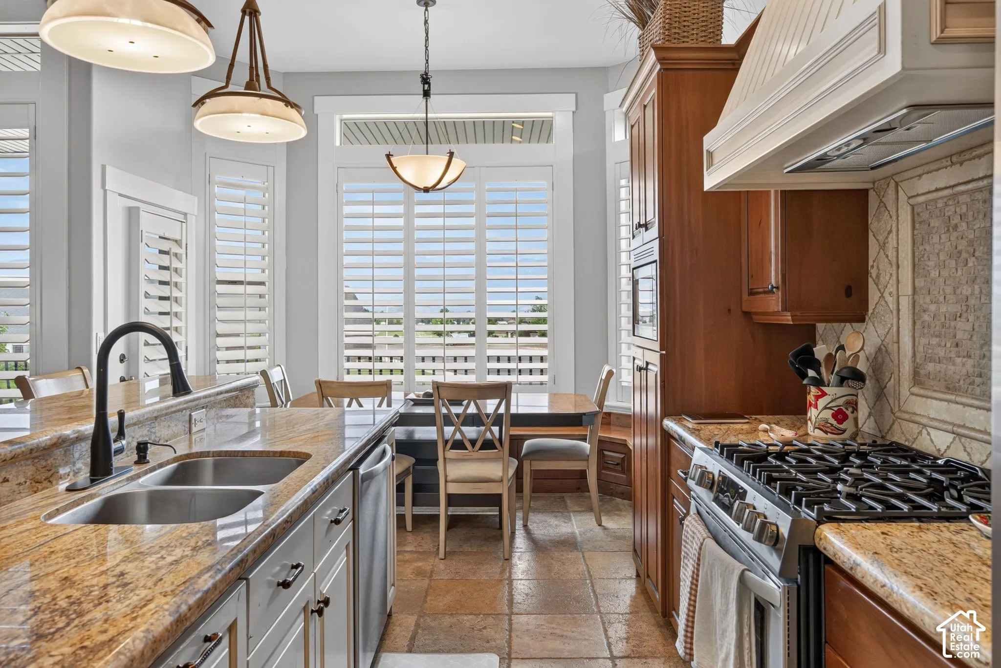 Kitchen featuring integrated appliances, shaker-style cabinetry, and a gas range