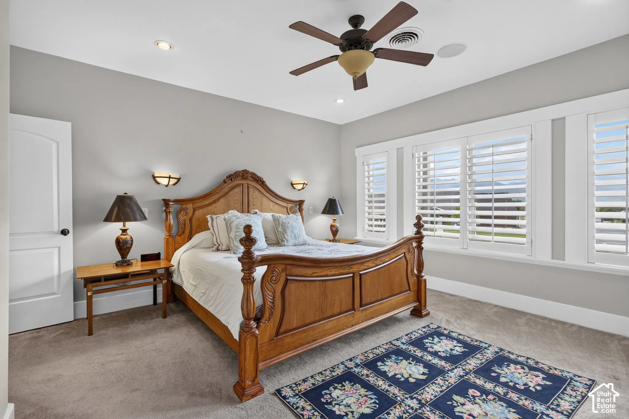 Recessed lighting, ceiling fan, carpet flooring, wall-mounted sconces, and white plantation shutters