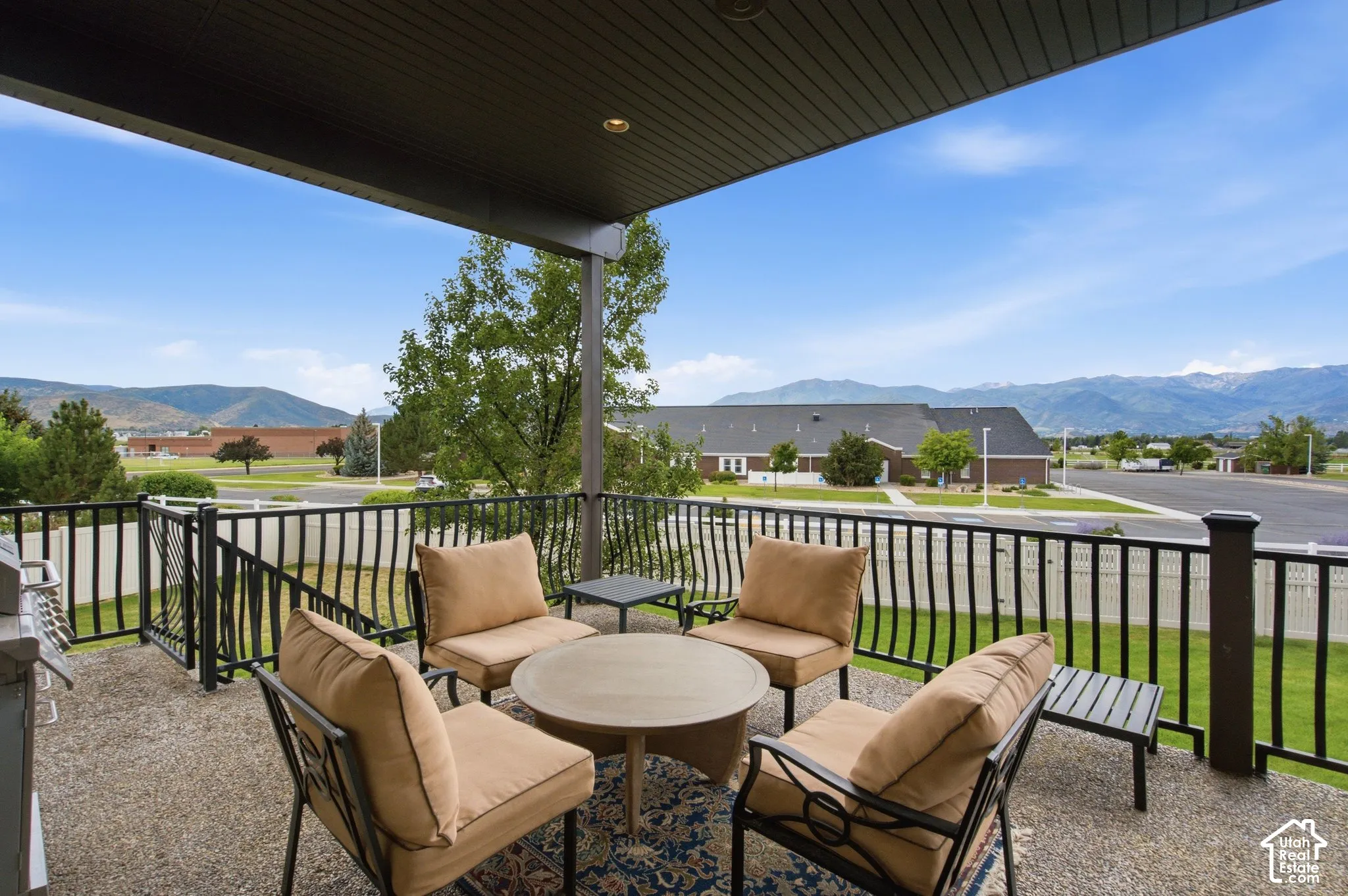 Covered patio featuring a textured concrete surface and black metal railing