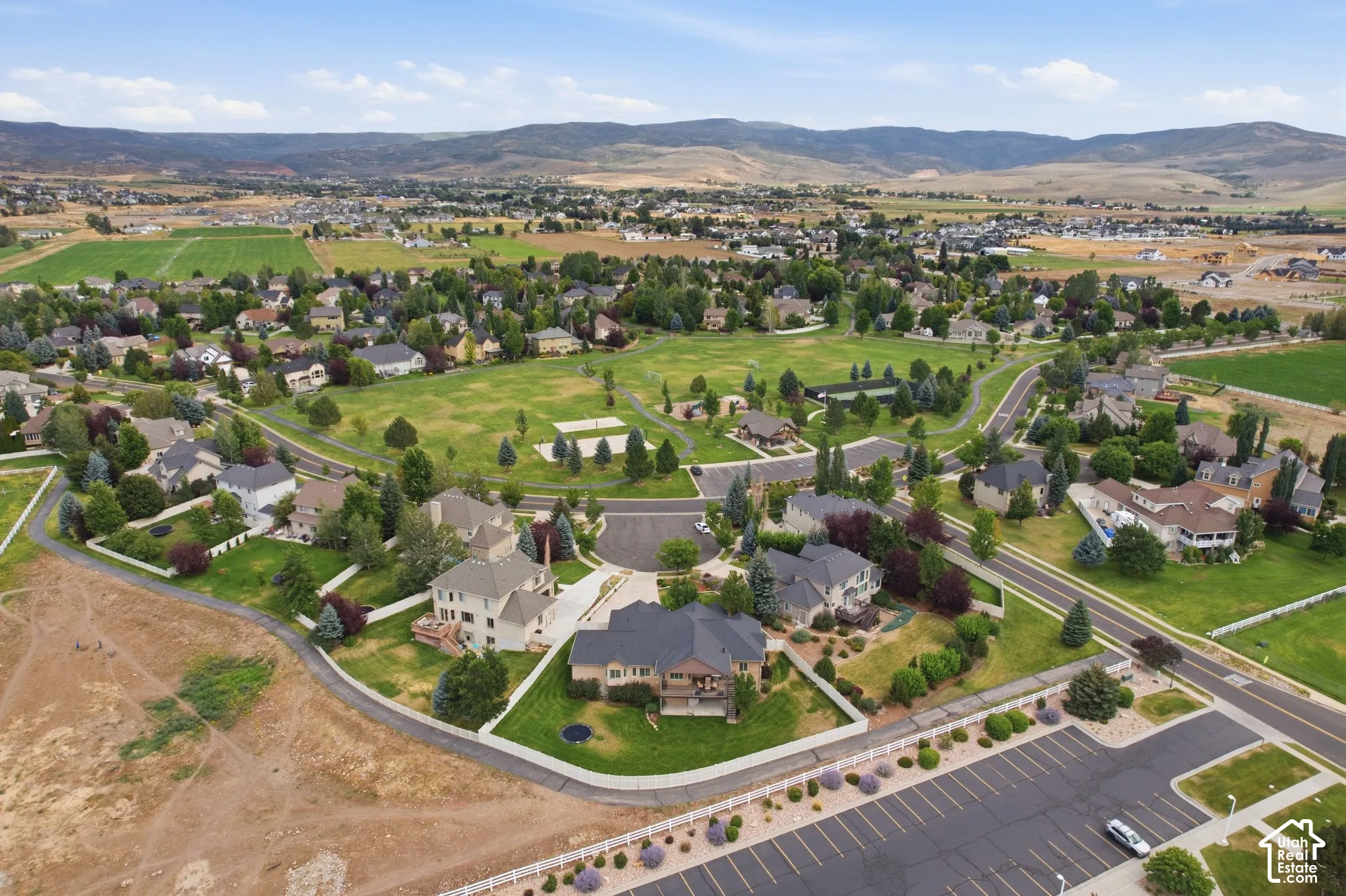 Expansive residential community with green spaces and mountainous backdrop
