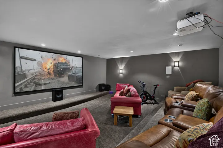 Screen image digitally altered - media room with a large projection screen, built-in sound system, and tiered seating platforms