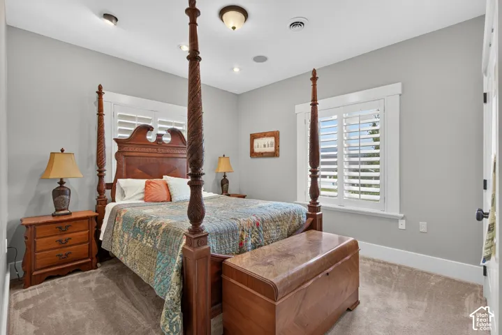 Recessed lighting, ceiling-mounted fixture, window with plantation shutters, light gray wall finish, and carpeted flooring