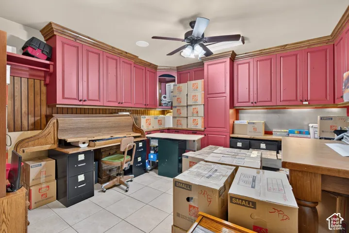 Built-in cabinetry with crown molding, wood paneling, and tile flooring