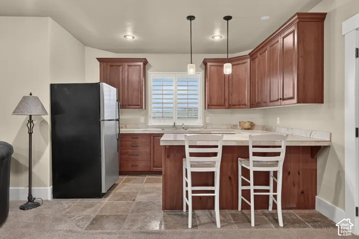 Wood-finish cabinetry with crown molding, light-toned countertops, and recessed lighting