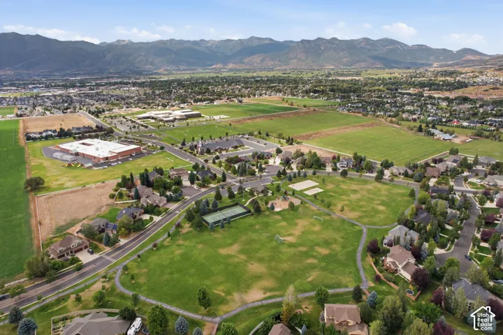 Expansive green spaces and residential properties surrounded by mountainous terrain