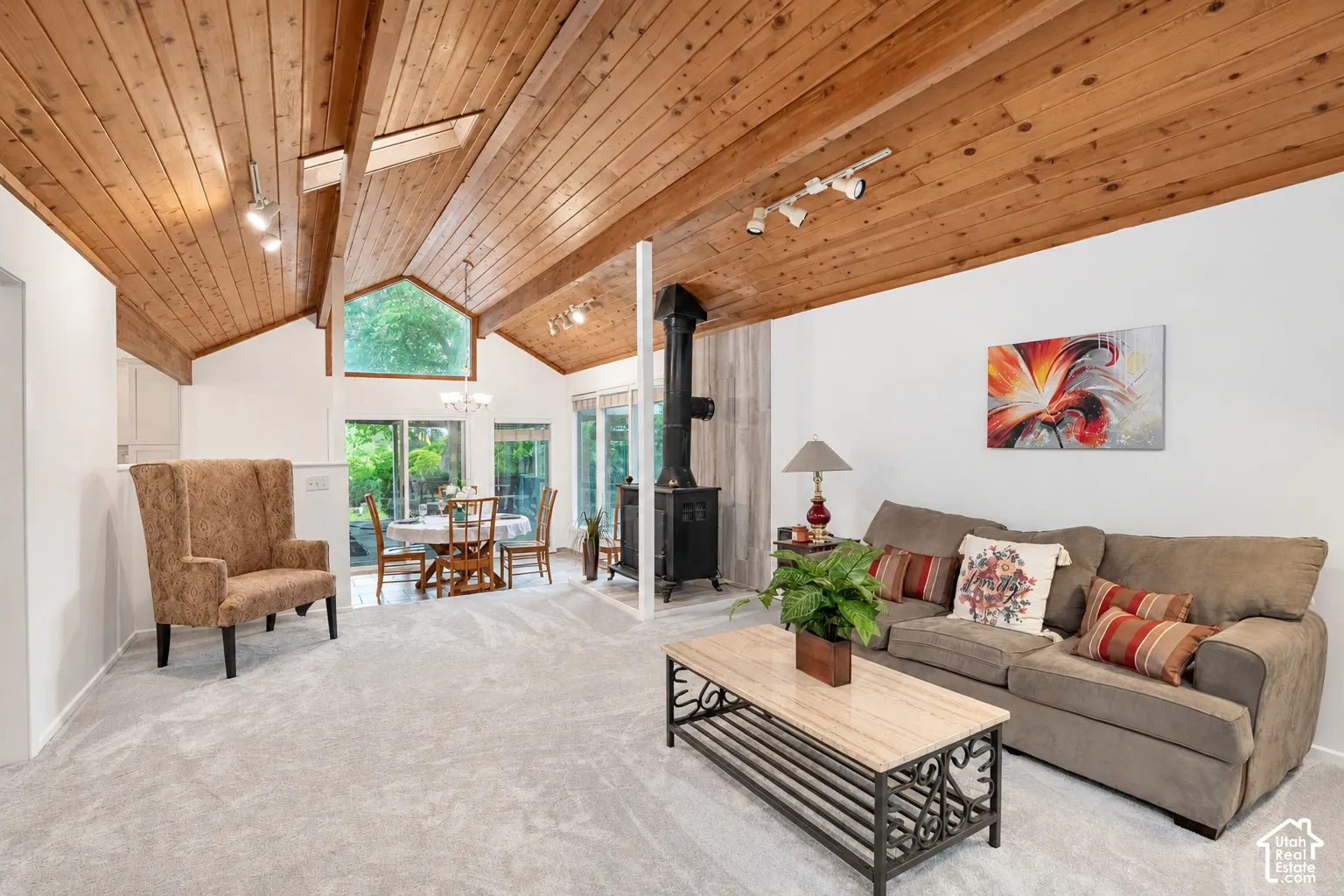 Vaulted wood-finish ceilings with exposed beams, skylights, and track lighting, wood burning stove, natural light, new carpet and paint
