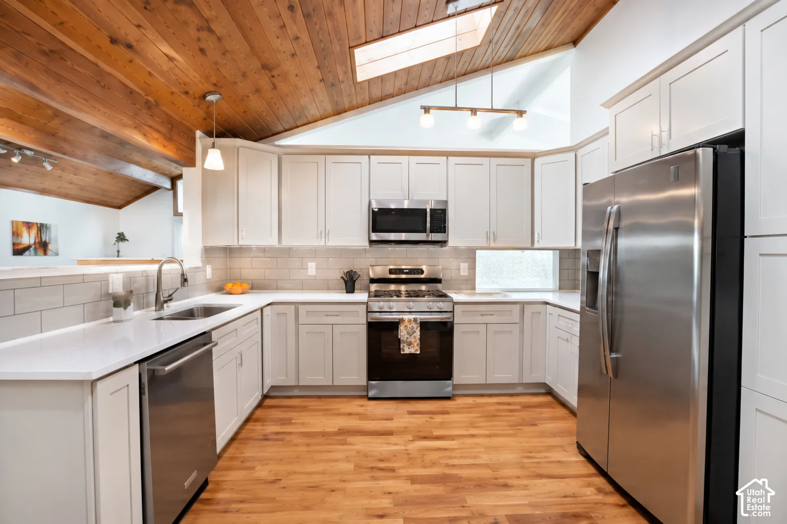 Vaulted wood paneling with skylights, new lighting, new cabinets, new stove and microwave, new quartz countertops, not sink, refinished hardwood