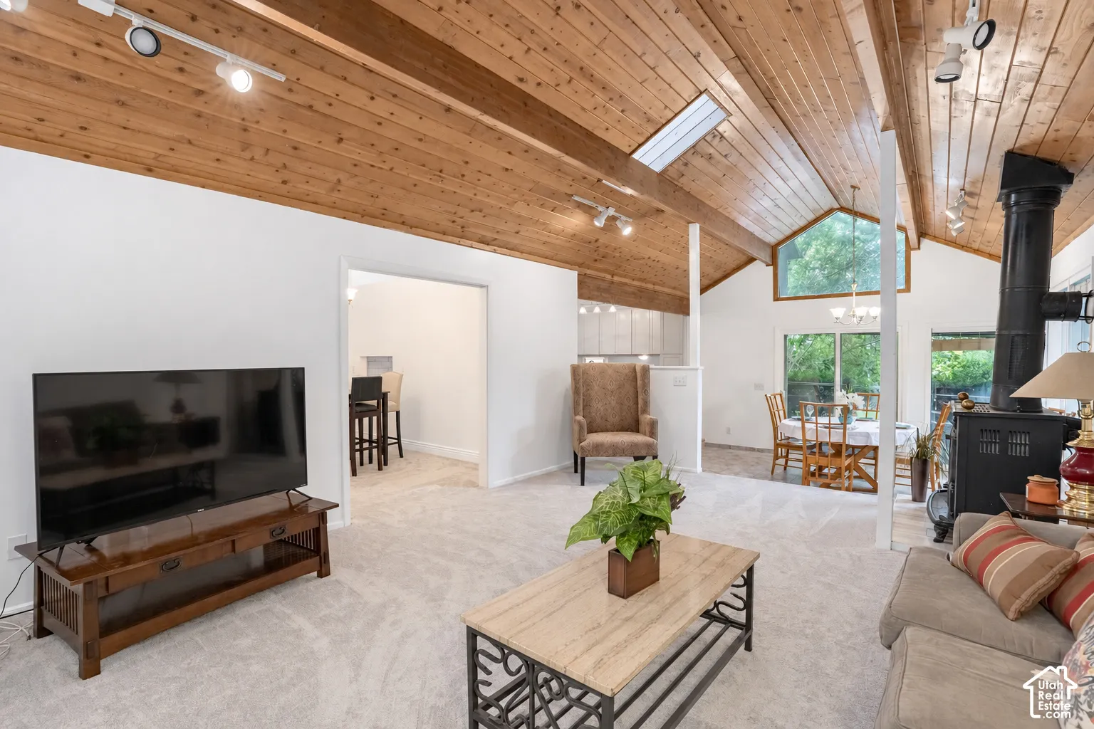 Vaulted wood-paneled ceiling with exposed beams, skylight, and track lighting