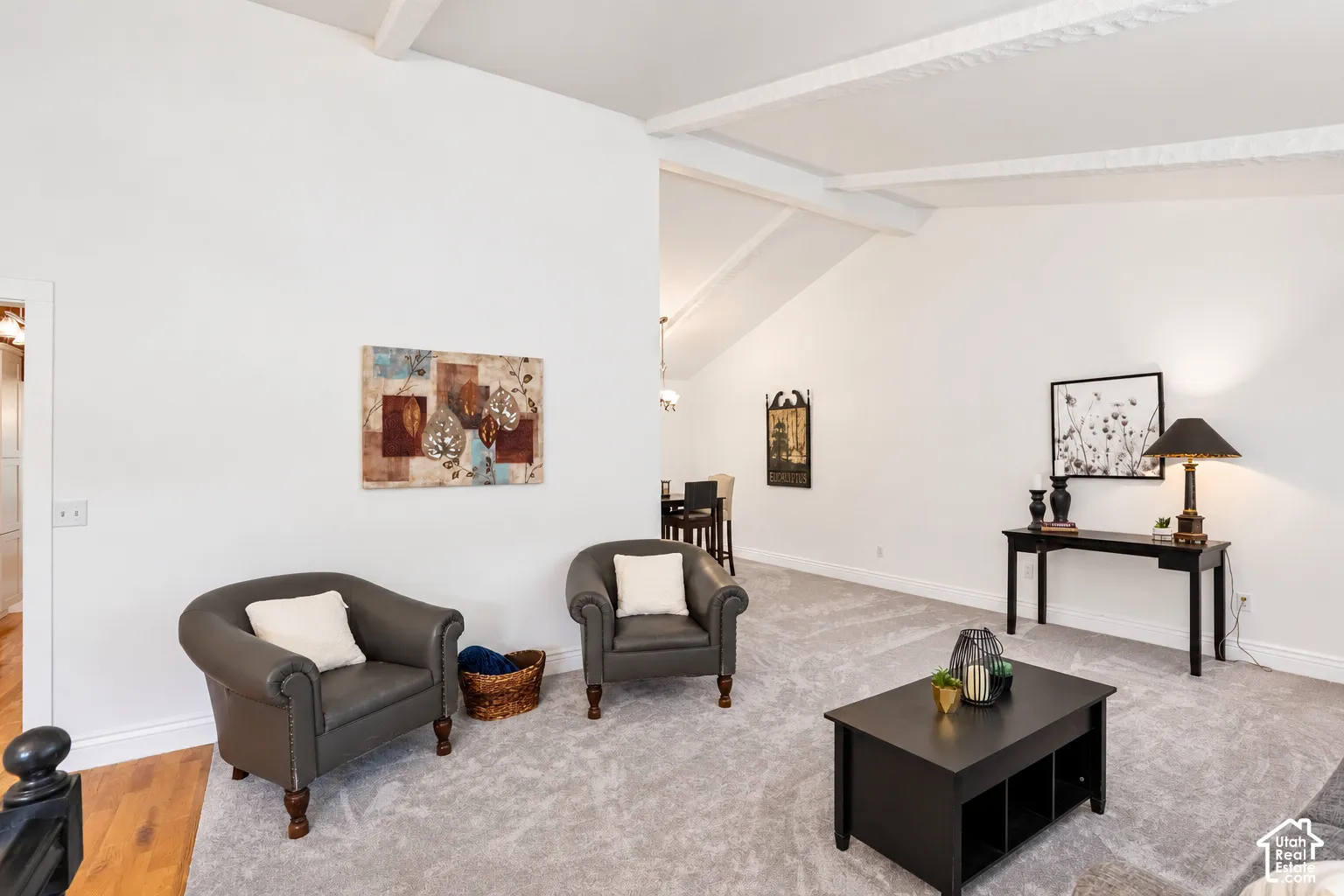 Vaulted ceiling featuring exposed beams, light-toned carpeting, and white wall finishes