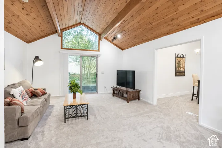 Vaulted wood-finish ceilings, an expansive window, and a glass sliding door with new blinds.
