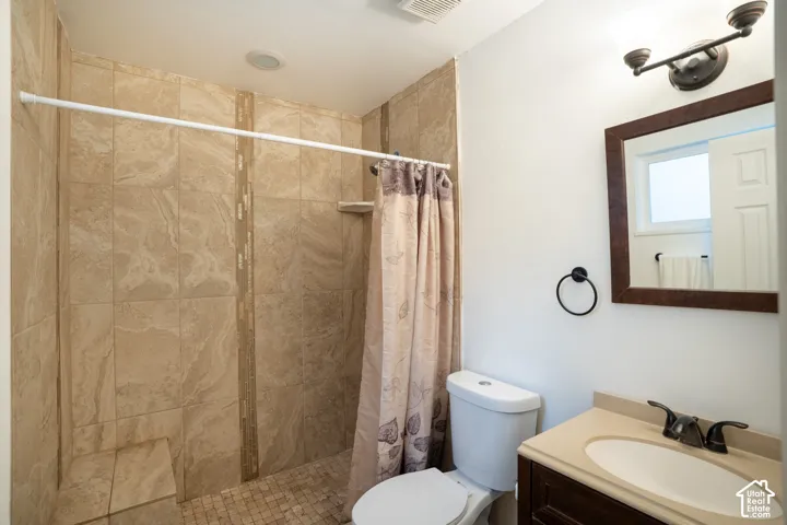 Tiled shower with a built-in bench, single vanity with an integrated sink, and a framed mirror